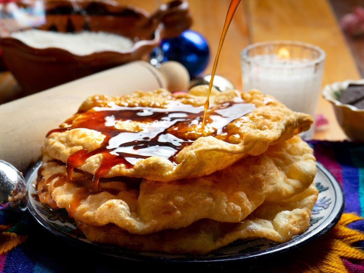 vertiendo almíbar sobre buñuelos de rodilla mexicanos