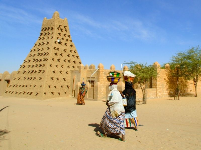 Gente caminando a la Mezquita Djinguereber en Tombuctú, Malí