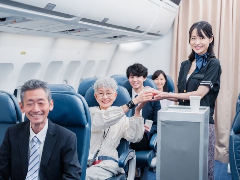 azafata que atiende a pasajeros en un avión