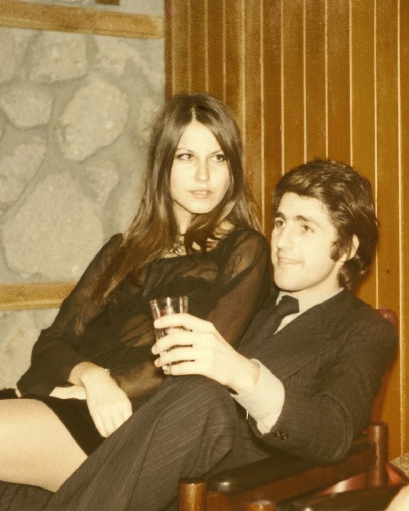 pareja sentada cerca de una pared con paneles de madera