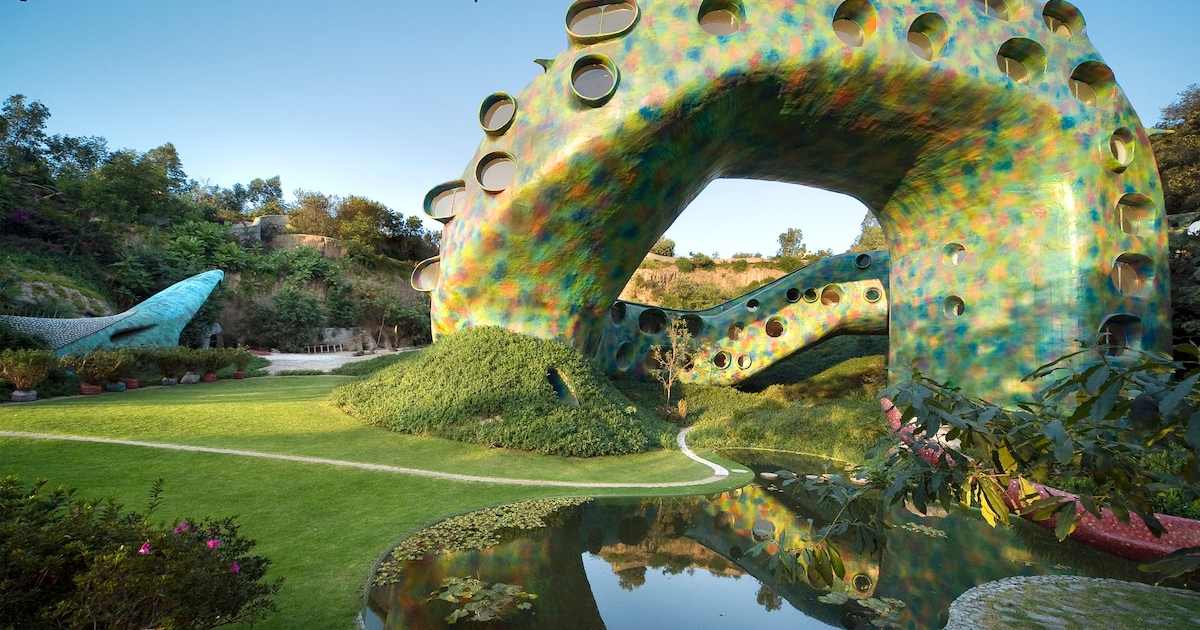 Mosaic-tiled body of the Mexico City snake house arching over a pond