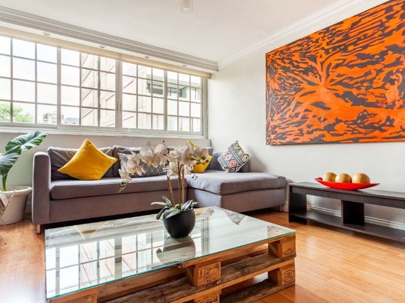 Sala de estar con una obra de arte naranja en el moderno Airbnb de 1 dormitorio en Polanco, Ciudad de México