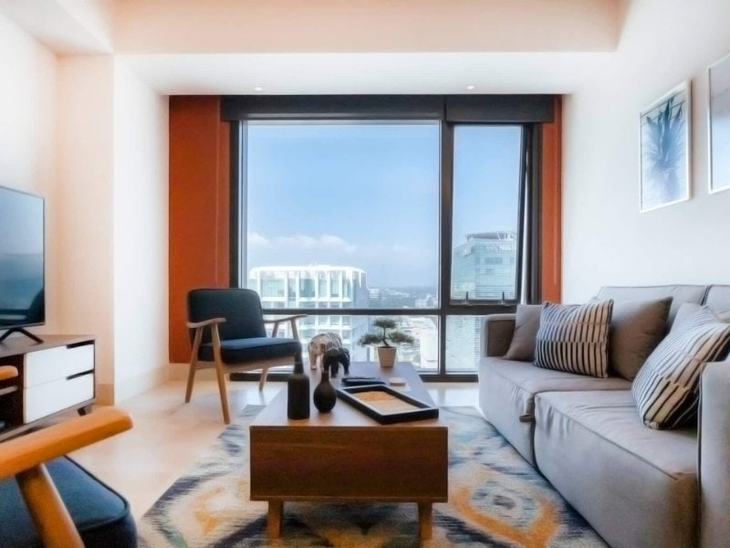 Sala de estar en el último piso con grandes ventanales en el departamento Airbnb con oficina en Polanco, Ciudad de México