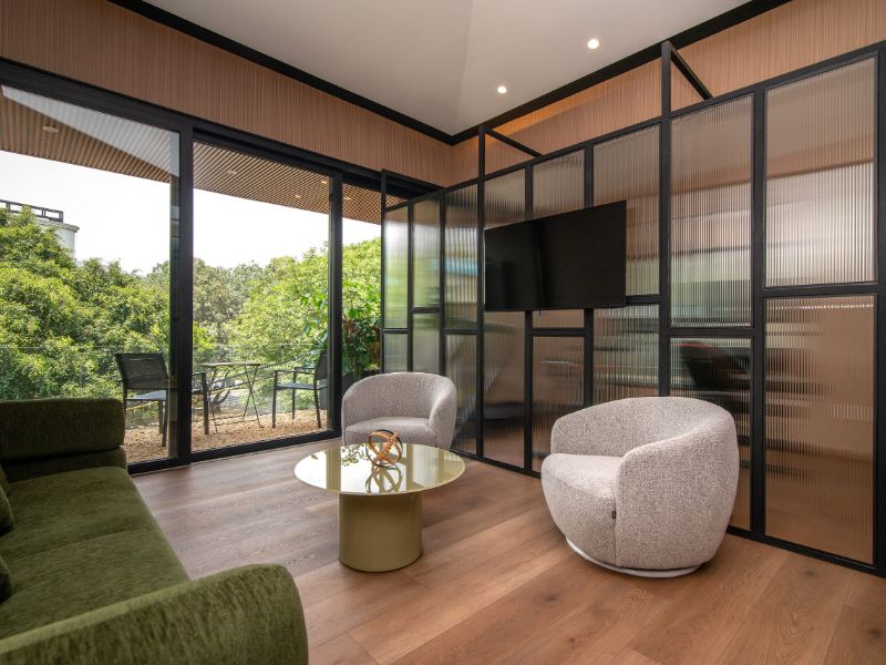Sala de estar con paredes de vidrio frente al jardín en Casa Nogal Garden Suite Airbnb en Polanco, Ciudad de México