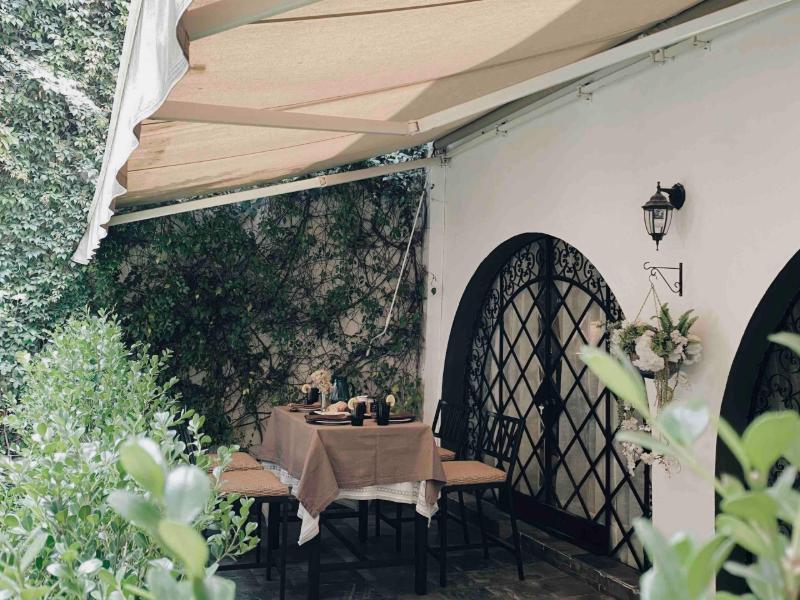 Patio con jardín y puerta de hierro arqueada en el Historic Fairytale Garden Loft Airbnb en Polanco, Ciudad de México