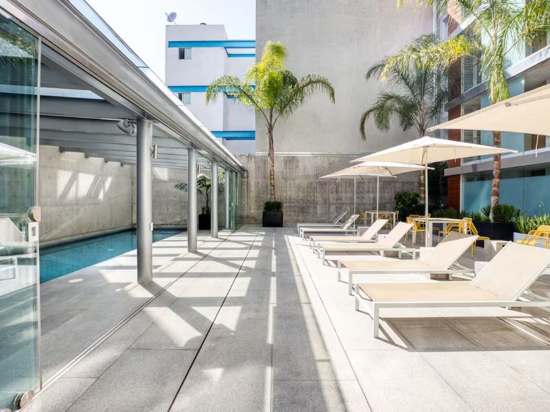 Piscina cubierta con camastros en el apartamento Antara Miyana Airbnb en Polanco, Ciudad de México