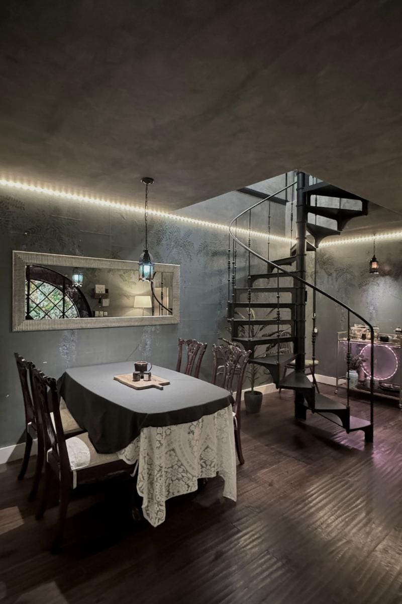 Mesa de comedor junto a una escalera de caracol en el Historic Fairytale Garden Loft, un Airbnb de Ciudad de México en Polanco