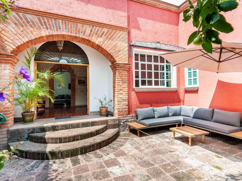 Patio de ladrillo y jardín en la casa colonial Airbnb en Coyoacán, Ciudad de México