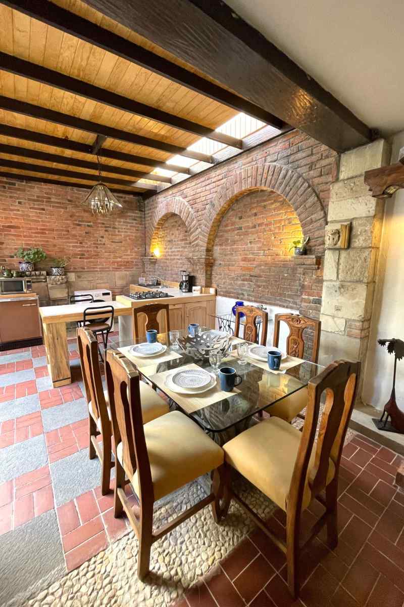 Mesa de comedor bajo una pérgola de madera en la casita Airbnb de Coyoacán con jardín privado, Ciudad de México