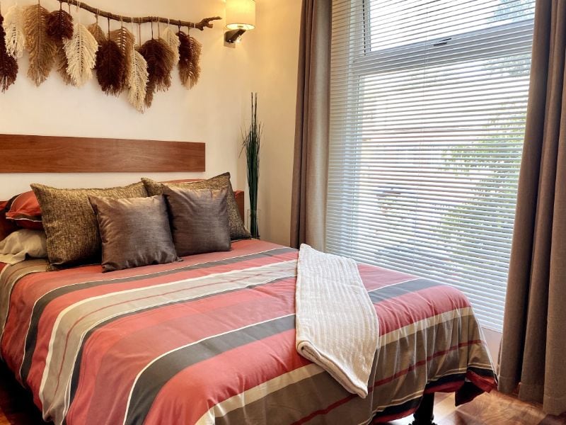 Dormitorio con colcha a rayas en Diego Loft Airbnb en Coyoacán, Ciudad de México