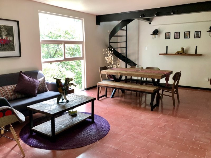 Sala y comedor con escalera de caracol en La Conchita Buhardilla Airbnb en Coyoacán, Ciudad de México