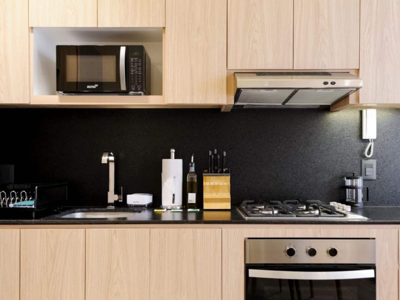 Cocina moderna con gabinetes de madera en el Departamento de 2 recámaras con terraza en Santa María la Ribera, un Airbnb barato en Ciudad de México