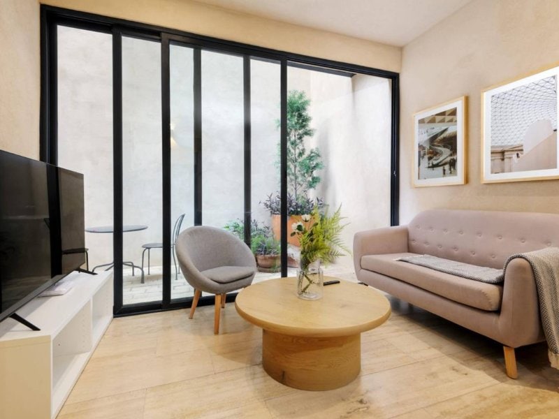Sala de estar con puertas de vidrio a la terraza en el Apartamento de 2 Recámaras en Santa María la Ribera, Ciudad de México