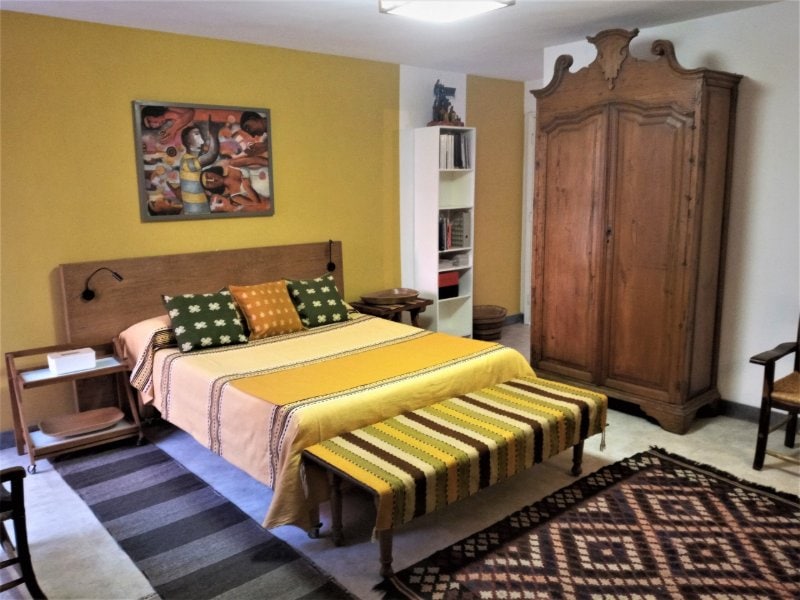 Cama con manta a rayas y armario antiguo en Garden Suite en San Miguel Chapultepec, un Airbnb económico en Ciudad de México