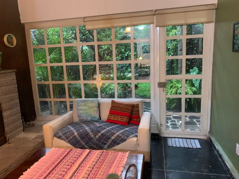 Sala de estar con ventana al jardín en Garden Home de 2 dormitorios en Coyoacán, Ciudad de México