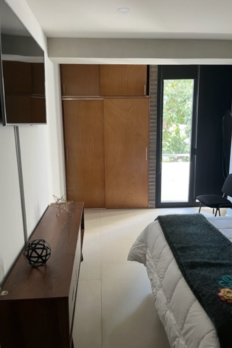 Dormitorio con closet de madera y puerta balcón en el Apartamento Cerca de Reforma en Tabacalera, Ciudad de México
