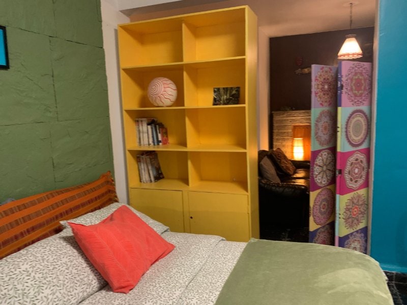Dormitorio colorido con una estantería amarilla en Garden Home de 2 dormitorios en Coyoacán, Ciudad de México