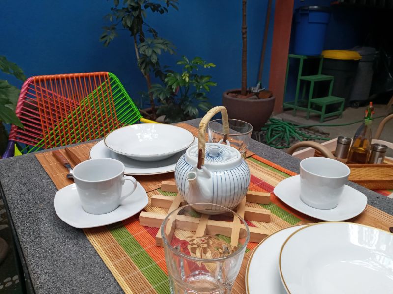 Mesa de desayuno con tetera en el patio-jardín de Garden Suite en San Miguel Chapultepec, Ciudad de México