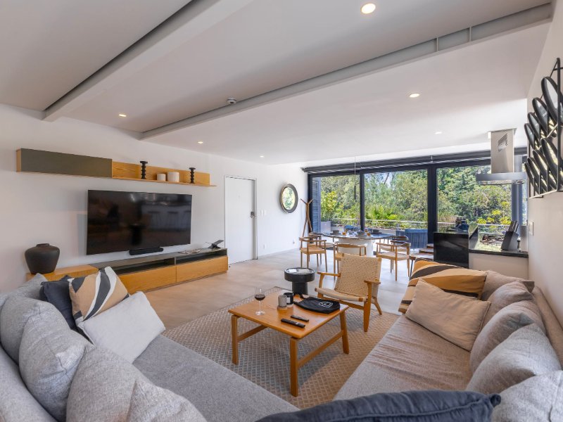 Luminosa sala de estar con sofá seccional y vista al parque en Capitalia Apartment with a Sunset Terrace en Polanco, un alquiler de lujo en Ciudad de México