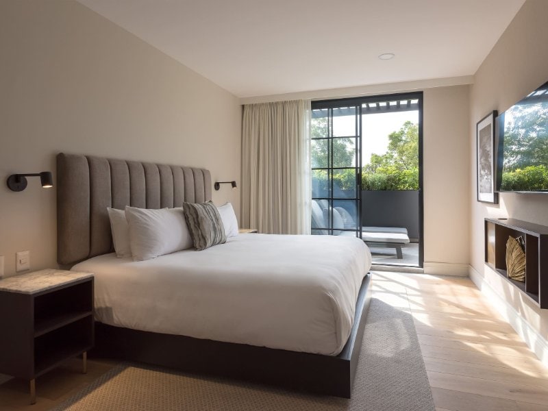 Dormitorio con una cama king y una puerta de vidrio a la terraza en la Suite Presidencial Terraza en The Amsterdam, Condesa, Ciudad de México