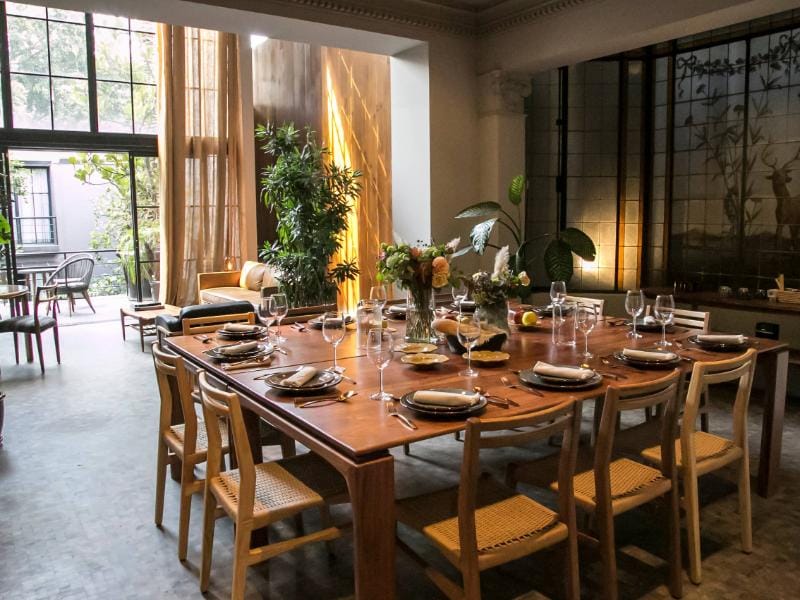 Mesa de comedor larga preparada para una cena en la mansión de diseño de 4 dormitorios con servicios de 1910 en Condesa, Ciudad de México