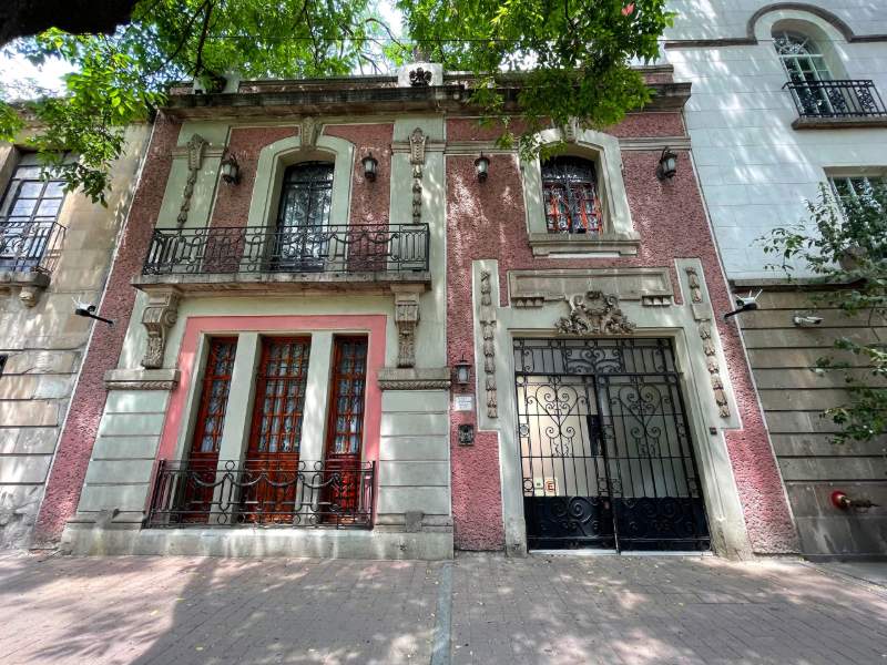 Histórica fachada rosa con balcones de hierro forjado en la Casa de las Campanas en Roma Norte, Ciudad de México