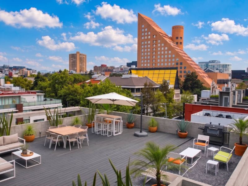 Terraza en la azotea con mesas de comedor y vistas a la ciudad en el Apartamento Polanco de 3 dormitorios de Masaryk en Polanco, Ciudad de México