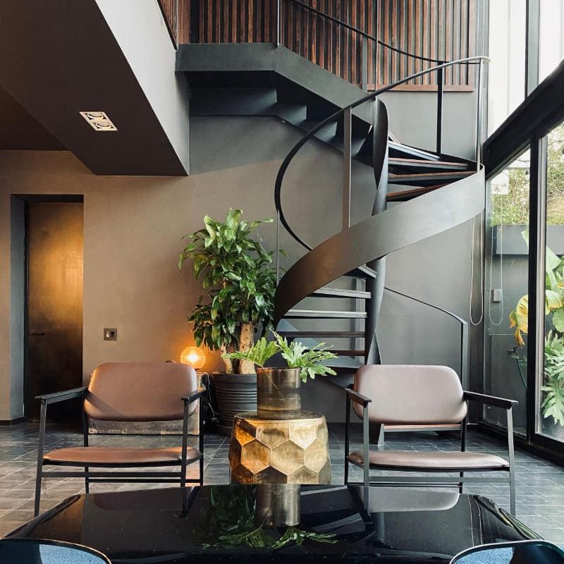 Escalera de caracol y sillones en Lavish in Black Airbnb en la Avenida Ámsterdam en Condesa, Ciudad de México