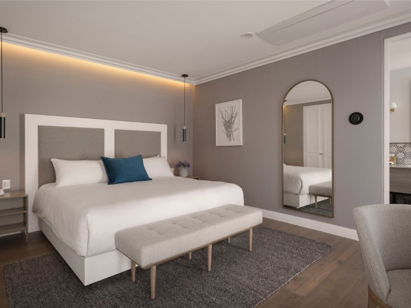 Cama King y espejo arqueado en la suite de Casa Cleo, frente al Parque México en Condesa, Ciudad de México