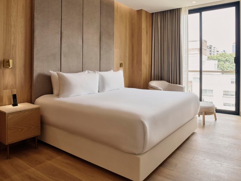 Cama King blanca y puertas de balcón en la tranquila y privada residencia con balcón en Polanco, Ciudad de México