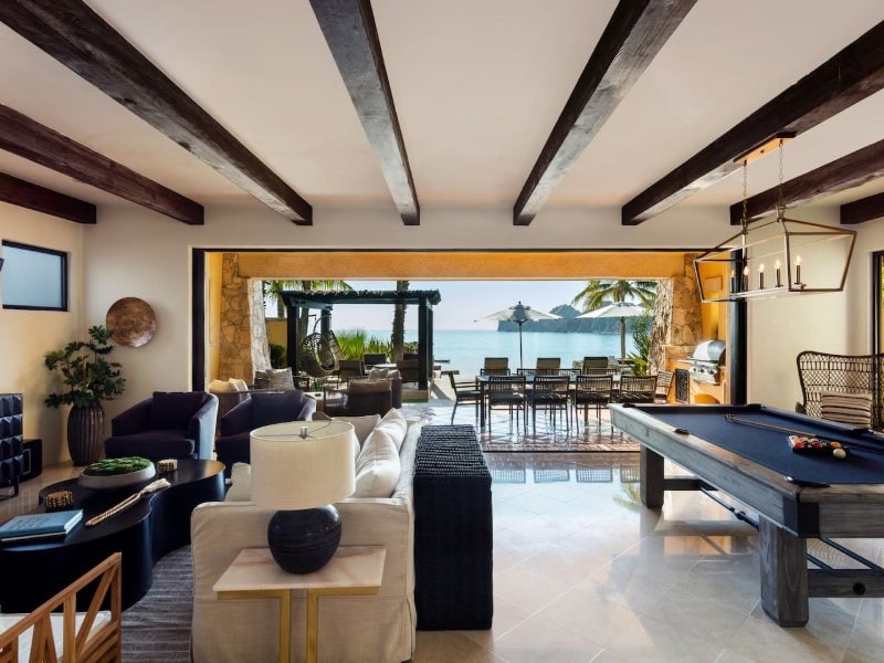 Sala de estar con mesa de billar que da a la playa Médano en Villa 1, Hacienda Beach Club, Cabo San Lucas