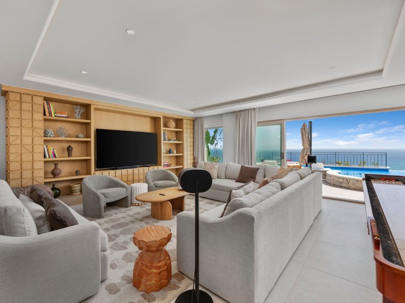 Sala de estar que da a la terraza de la piscina con vista al mar en Casa La Maraca en Pedregal, Cabo San Lucas