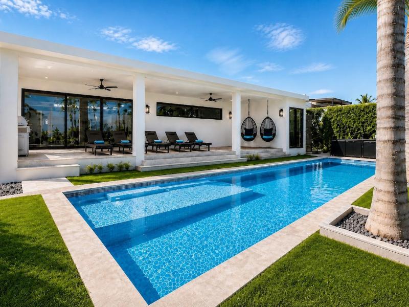 Piscina de entrenamiento y patio cubierto con sillas colgantes en Villa Utopia en Cabo San Lucas