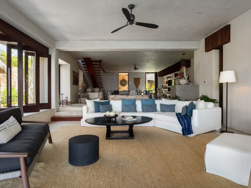 Sala de estar con sofás blancos que dan al jardín en Casa Koko en Punta Mita
