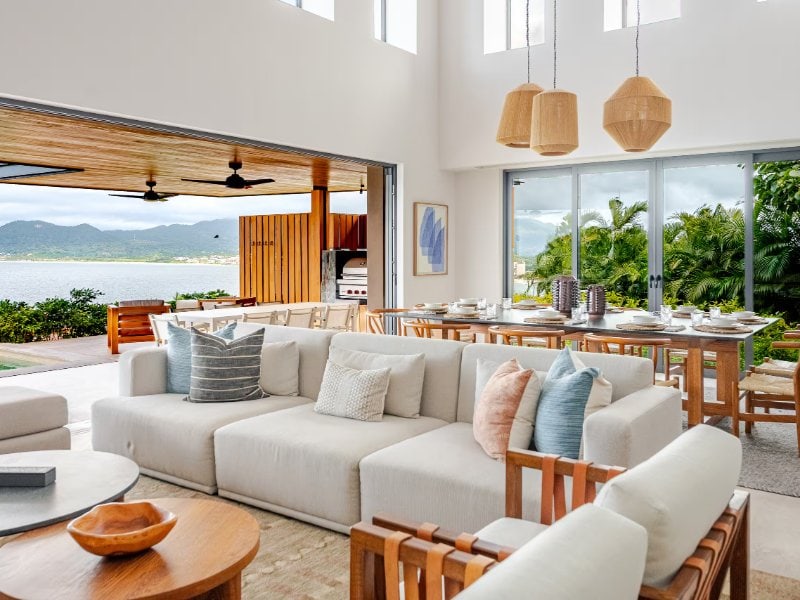 Sala y comedor que dan a la terraza con vista a la bahía en Casa Juntos en Punta Mita