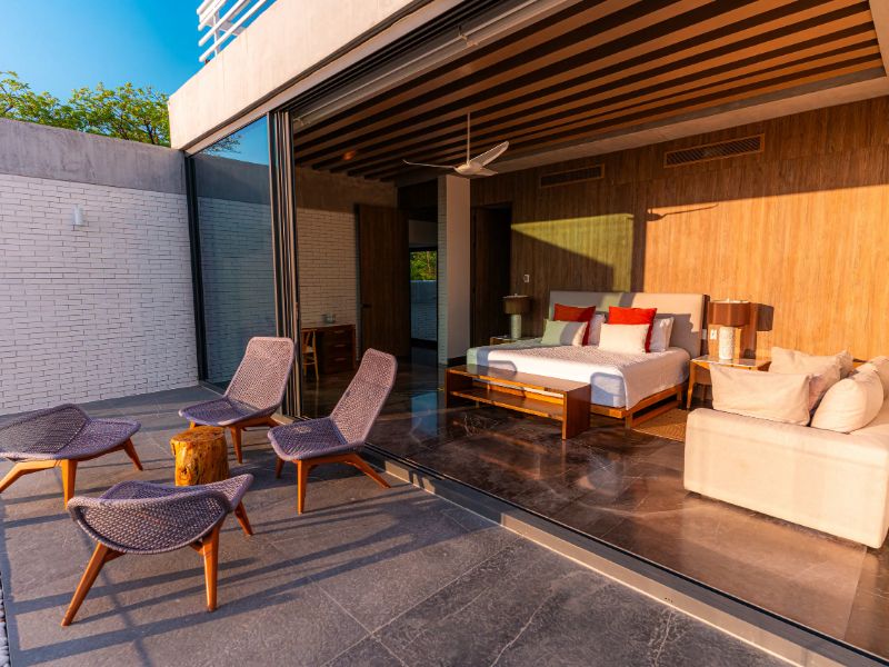 Dormitorio que da a una terraza con sillones en Casa Niyé en Bolongo, Punta Mita