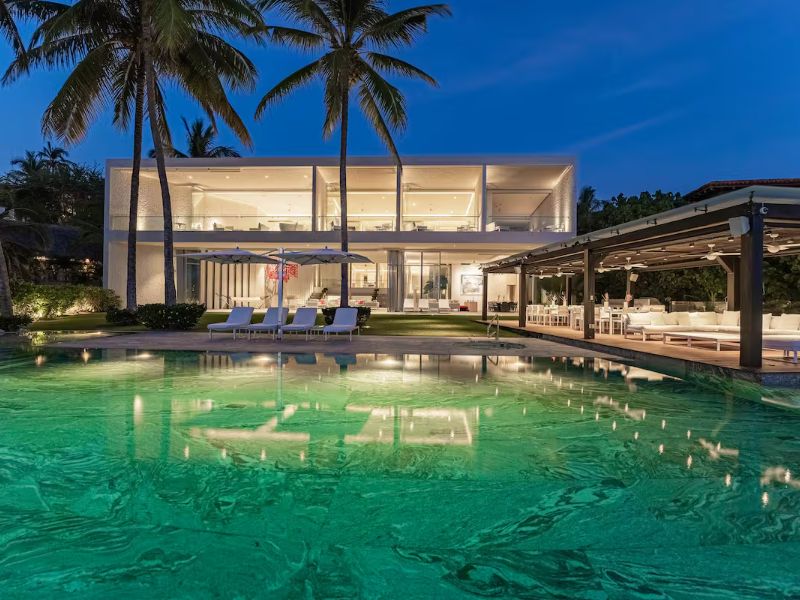 Piscina iluminada al anochecer frente a Breeze 5-18, una villa frente al mar en Punta Mita de Teodoro González de León