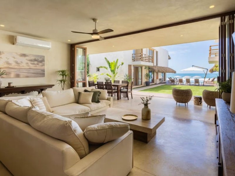 Sala de estar con vista al jardín frente al mar en Villa Chukum en Punta Mita